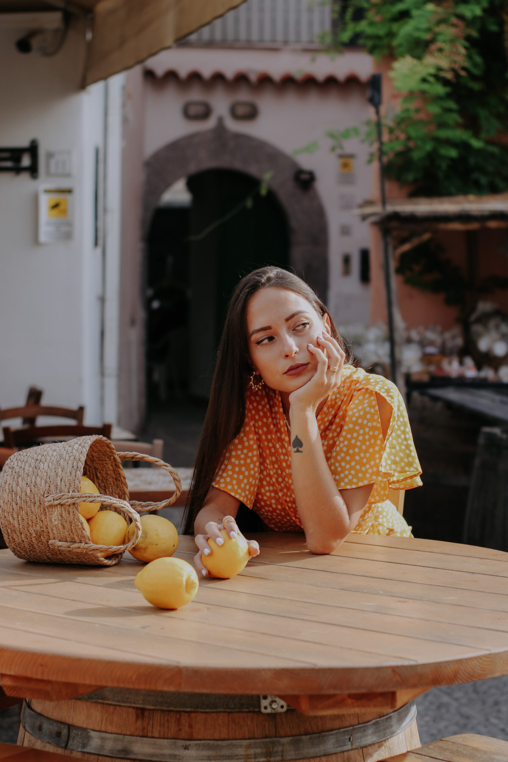 Woman sitting by table with lemons